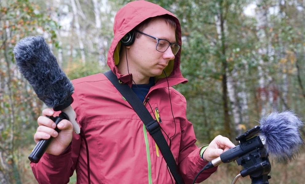 Young man with microphones in the forest